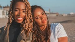两个黑人妇女对着镜头微笑。