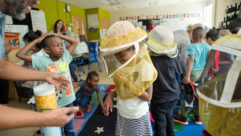 快乐学习的学生穿着bee-protection头部覆盖