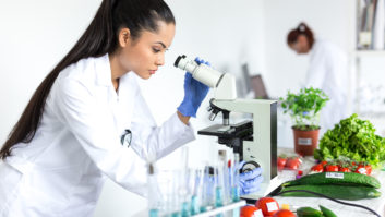 女性使用显微镜在实验室微生物学家,研究蔬菜。