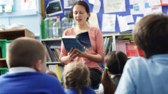 老师在教室前面读一本书为青年学生文章故事构建学生的应变能力