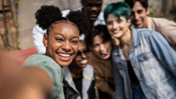 年轻的黑人妇女带着selfies朋友在街上文章在高等教育健康计划
