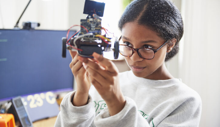 黑人少女戴眼镜保持机器人的技术文章拥抱科技