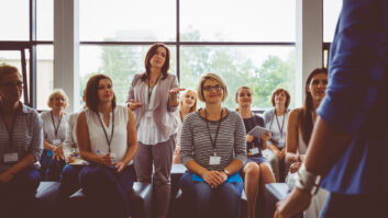 商人提高一个演讲者在培训的问题。女人在研讨会期间提问。对教师专业发展的文章
