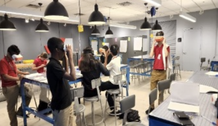 几个学生戴上虚拟现实眼镜作为文章他们走过教室可持续发展课程